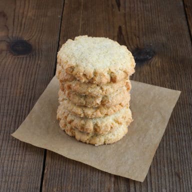 A stack of six lavender shortbread cookies on a napkin