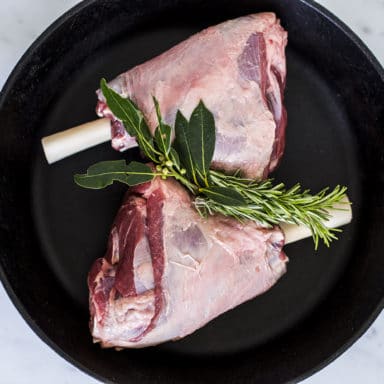 Two shanks of lamb with rosemary and other herbs between