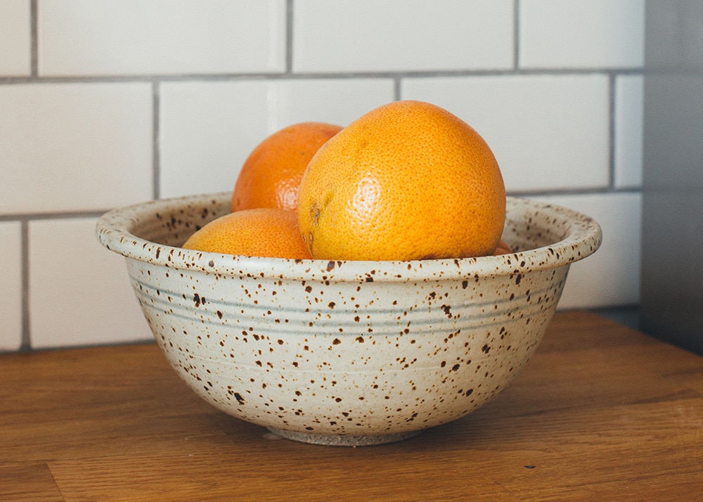 A bowl of three large oranges