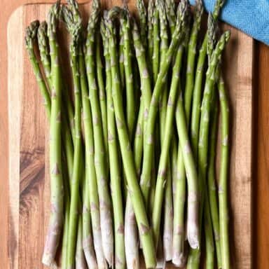 Bunch Of Asparagus On Wood With Blue Napkin Cutting Down Upper Right Side