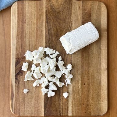 Crumbled Cheese Log Over Cutting Board