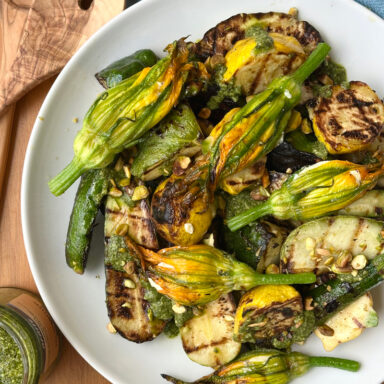 Grilled Squash And Squash Blossoms With Pesto Mixed On Plate