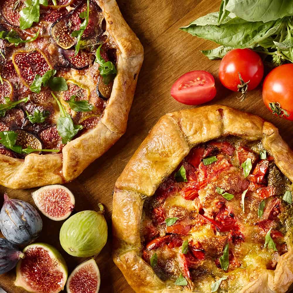Two Galettes Surrounded By Ingredients On Wood